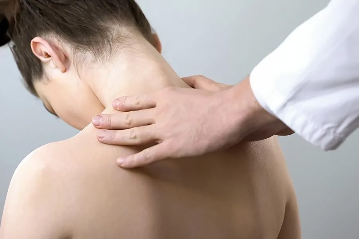پزشک در حال معاینه بیمار که دیسک گردن دارد
